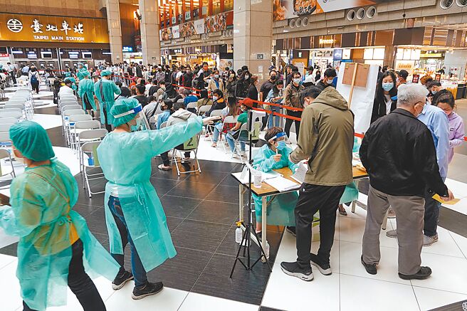 新冠肺炎本土疫情持續嚴峻，連日來確診病例數突破6萬，台北車站大廳的疫苗接種站15日湧入數百人排隊施打。（黃世麒攝）