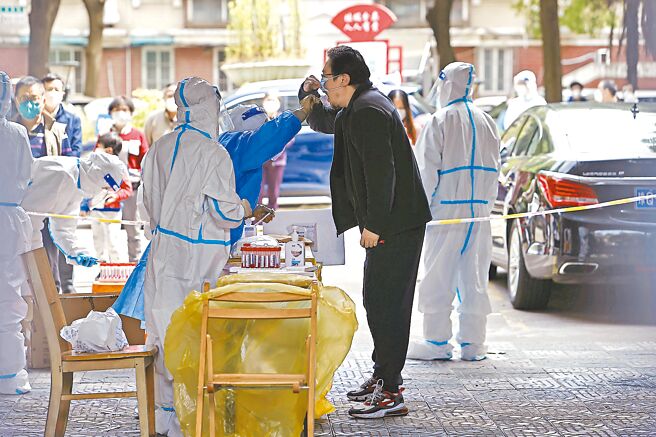 歷经封控近2个月，上海市从16日起分阶段推动復商復市，并针对「人能出、车能动、货能转」的目标，提出四大制度设计。图为上海市杨浦区的医护人员正在核酸採样。（中新社）