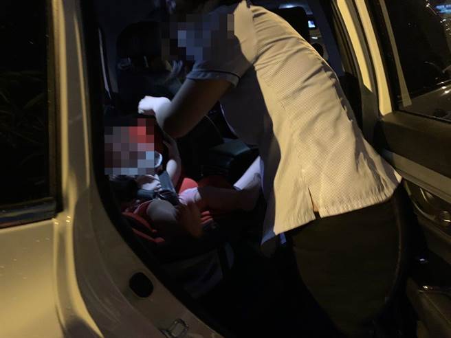 在警方协助下，廖姓妇人终于能下车将孩子放回安全座椅。(警方提供／林欣仪台中传真)