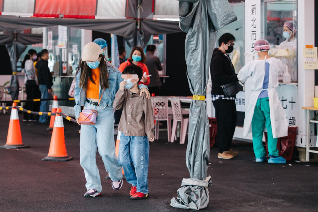 国内疫情严峻，不少家庭也出现全家确诊的状况。图为家长带孩子到板桥江子翠大型筛检站做PCR。（图／郭吉铨摄）