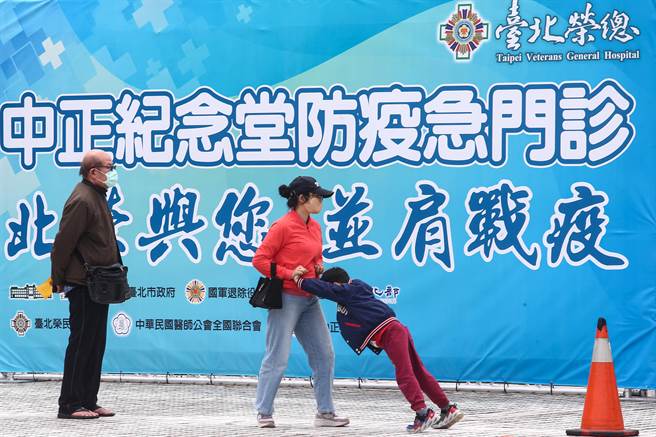 台北市政府和台北榮民總醫院在中正紀念堂開設車來速篩檢站，17日正式啟用，民眾在做好安全距離下，排隊等待篩檢，一位小朋友等待篩檢時，與家長互推打發時間。（鄧博仁攝）