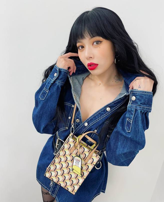 泫雅摆弄着她身上的布料，胸前曲线就在深V中即将见客。(图/泫雅 IG)