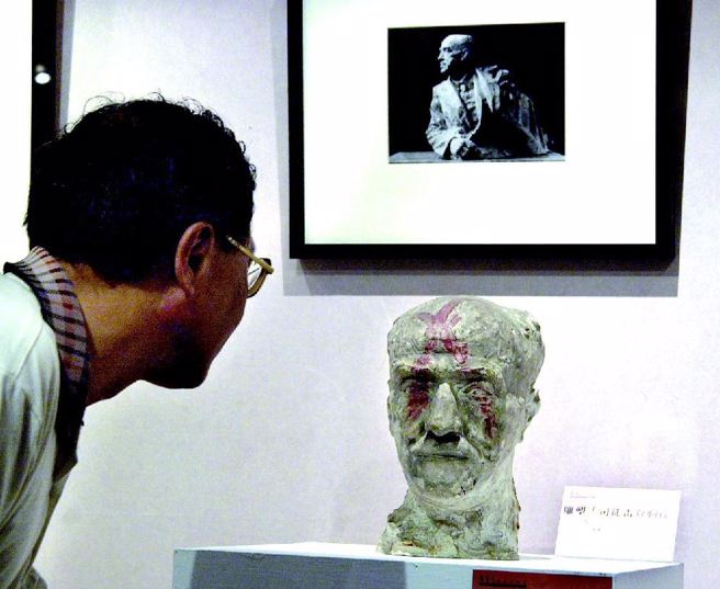 图为1947年为当时美国驻华大使司徒雷登所塑之雕像，在文革时被毁坏，仅剩头部还可见脸颊被喷上×红漆，上方照片为原作品。（邓惠恩摄）