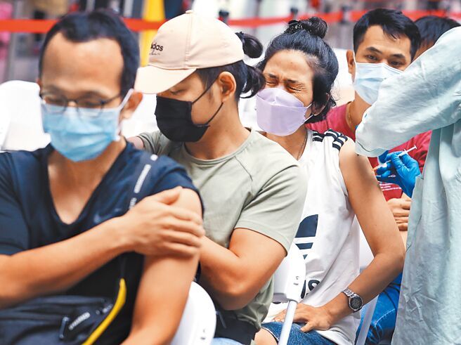 国内疫情急遽升温，也让学校教学陷入混乱。图为打疫苗的民眾。（范扬光摄）