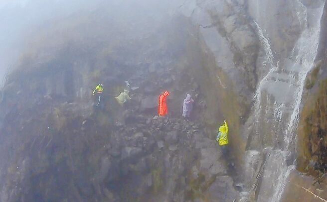 阿里山眠月线是近年热门登山路线，也屡传意外求援状况，日前有登山客通过眠月线大崩壁时，遇上因雨势造成的瀑布而受困，搜救人员冒险救人，事后登山客被批评下雨天硬上山是浪费社会资源。（嘉义县消防局提供／吕妍庭嘉义传真）