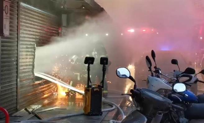 警消以破坏器材割破铁卷门入内灌救。（翻摄画面）