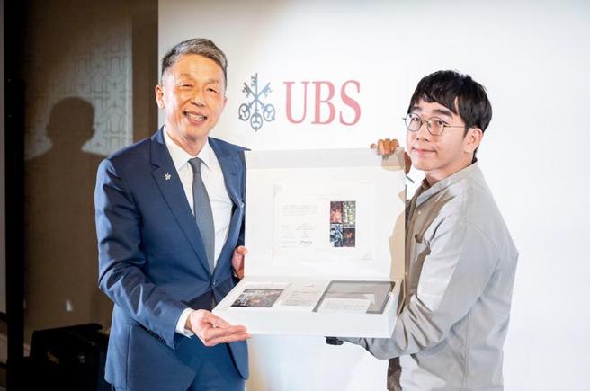 （瑞银集团台湾区总经理陈允懋（左）向台湾年轻艺术家彭奕轩致谢创作「艺企做爱心」（U Art Charity）年度项目。图／瑞银提供）