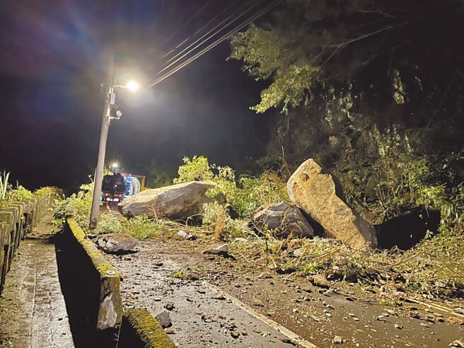 由於連日豪雨，烏來信福路隧道口山坡巨石崩落，意外發生後，警方到場協助警戒、疏導交通，全線道路封閉，相關單位趕往搶修。（警方提供／李奇叡新北傳真）