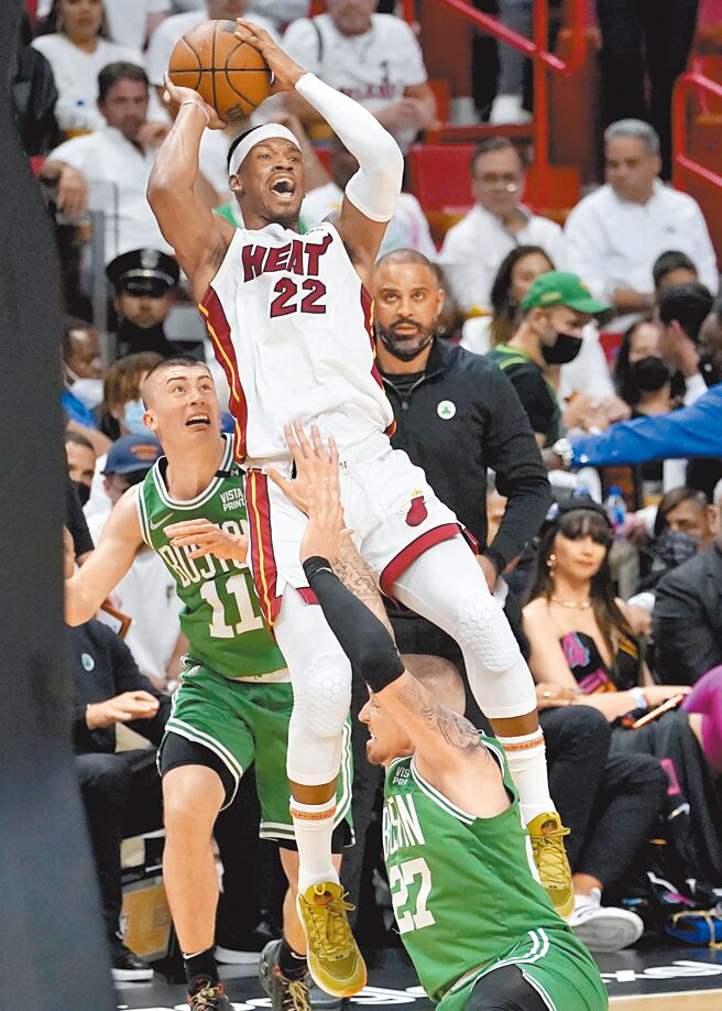 熱火前鋒吉米巴特勒在塞爾提克球員的防守下，失去重心仍想嘗試投籃。（美聯社）