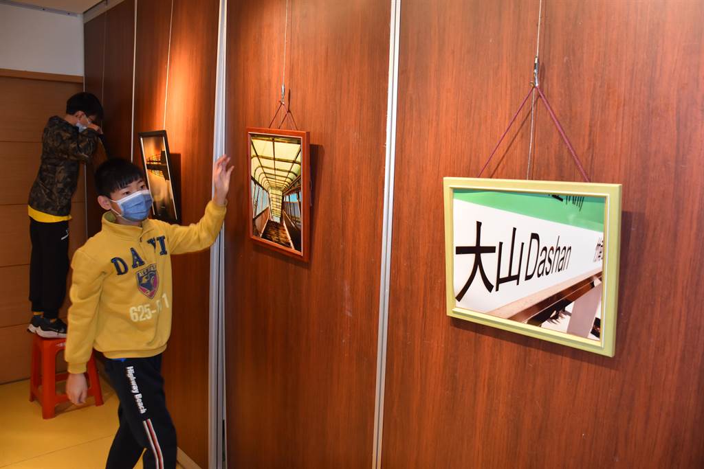 談文國小學生攝影展,學生自行布置掛圖。(謝明俊攝)