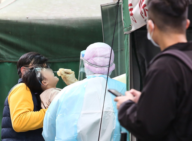 国内染疫儿童併发脑炎个案，截至目前已累计3例，中央流行疫情指挥中心今表示，将与神经医学专家讨论，制定共通性处置原则因应。图为家长带孩子到快筛站做筛检。（资料照）