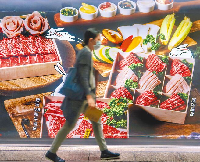 疫情攀升衝击餐饮业，经济部推出餐饮行销补助，但对于行销经费才编列6亿元，不分党派委员都忧心钱不够。图为民眾走过餐饮广告看板。（本报资料照片）