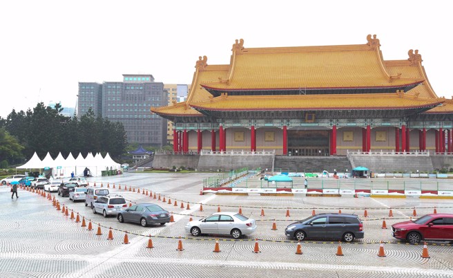 图为新冠肺炎本土疫情急遽升温，确诊人数攀升，为有效分流医疗量能，台北市政府与台北荣民总医院合作在自由广场设置防疫急门诊，提供车来速PCR筛检、看诊、给药、「三合一」服务，19日许多民眾一早就开车或是骑车前往排队筛检。（资料照/陈俊吉摄）
