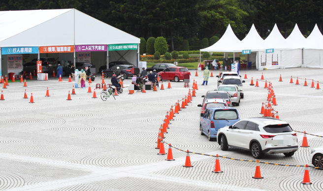 本土疫情严峻，民眾在中正纪念堂车来速筛检站排队接受PCR採检。（张铠乙摄）