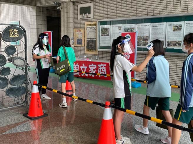 国中教育会考登场，考生进入曾文家商考场时量体温。(刘秀芬摄)