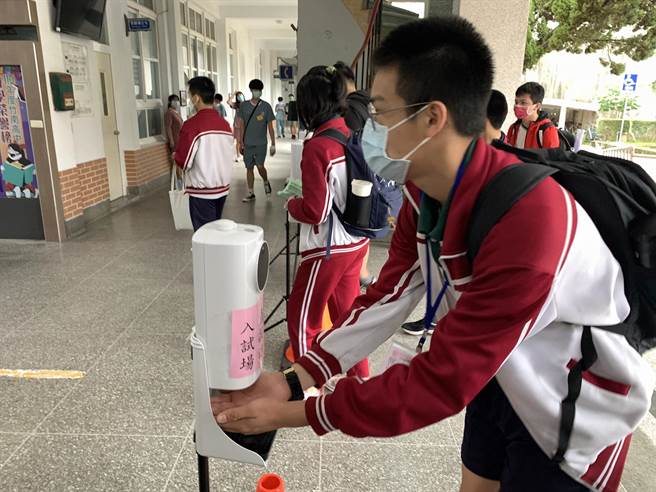 21、22兩天舉行國中會考，考生進入試場前都須消毒及量測體溫。（讀者提供／謝明俊苗栗傳真）