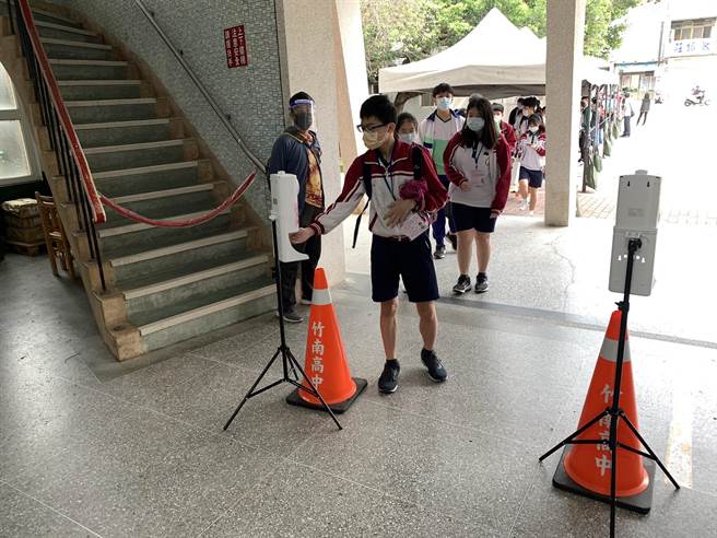 21、22兩天舉行國中會考，考生進入試場前都須消毒及量測體溫。（讀者提供／謝明俊苗栗傳真）
