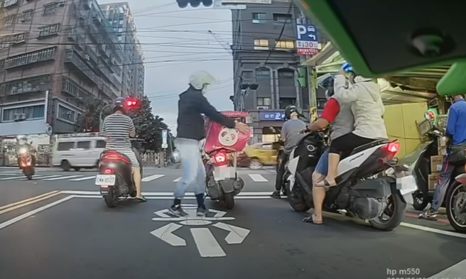 外送员被发现外送箱在路中倾斜，有1个明显开口，餐点可能随时掉出，所幸停等红灯时，后方1名骑士好心上前提醒，外送员才赶紧下车乔正箱子。（翻摄自YouTube频道「WoWtchout - 地图型行车影像分享平台」）