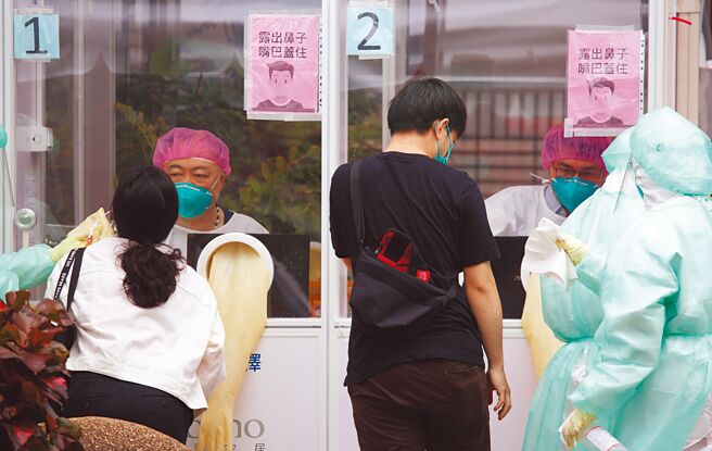 本土新冠疫情连环爆，医疗量能逐渐吃紧，北市联医防疫急门诊20日一早民眾在筛检站前接受PCR筛检。（张铠乙摄）