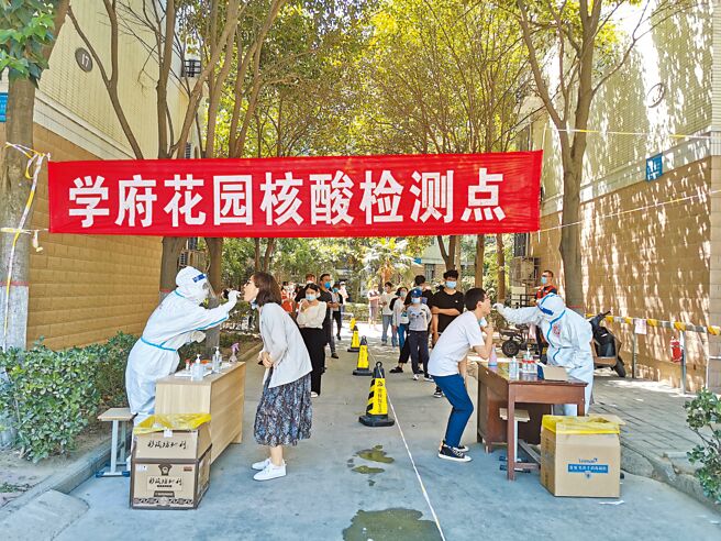 大陸力推核酸檢測常態化，以防止大規模封城，這背後涉及龐大產業鏈，有關企業也獲利不少。圖為河南鄭州居民在社區進行核酸檢測採樣。（中新社）