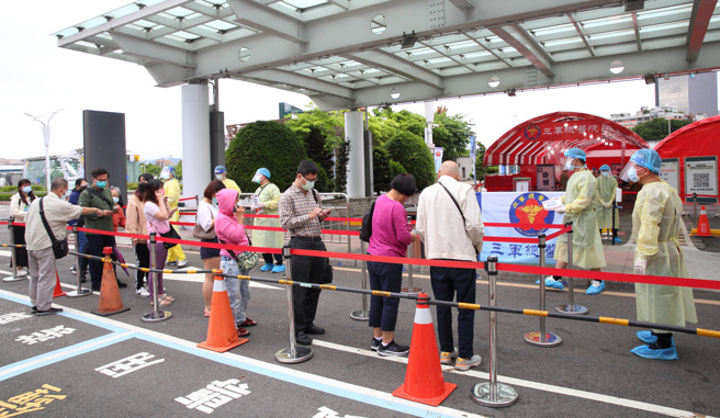 圖為中央流行疫情指揮中心加開松機篩檢站紓解量能，並符合民眾需要，且考量台北市很忙碌，不敢再勞煩市府，松機篩檢站啟用後，醫護人員為民眾做PCR篩檢。（張鎧乙攝）