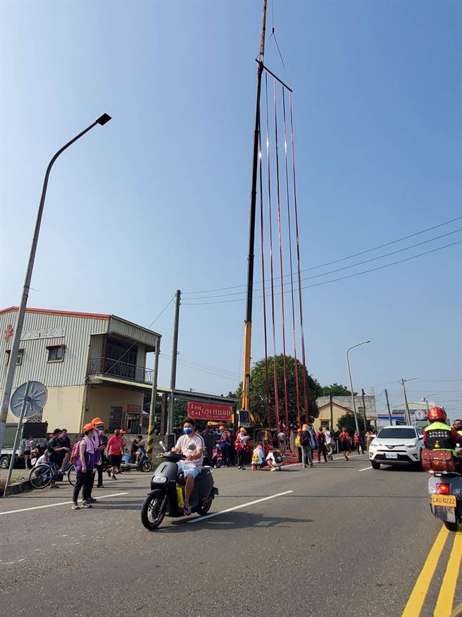 台19線進入北港鎮後，沿途有許多怪手懸掛幾十米高的鞭炮迎接。（周麗蘭攝）