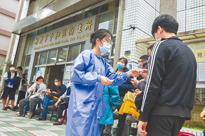 为拿到纸本居家隔离书，中和卫生所前大排长龙，现场工作人员一一分发号码牌后採一进一出方式，让等待民眾依序进入办理。（本报资料照片）