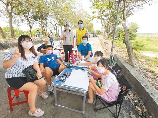 台南市安定区公所于苏厝滞洪池旁阿勃勒花道办写生比赛，区长李耀州（后右）、台南市议员林志展（后左）到场加油打气。（刘秀芬摄）