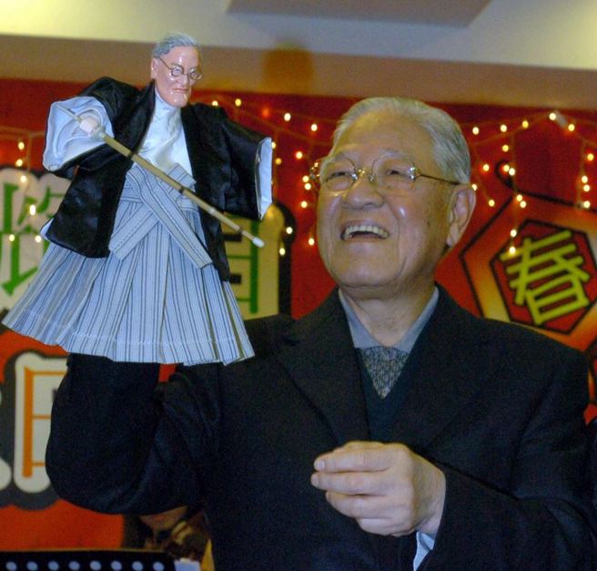 李登輝前總統八十四大壽時的暖壽宴會中支持者特別送給他一具穿著日本武士裝的阿輝伯，讓他高興的舞弄著。（季志翔攝）