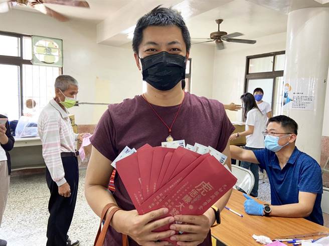 考量疫情衝击经济，九如乡发放每位乡民1000元振兴金，男子代替家人领取，共领了9份。（林和生摄）