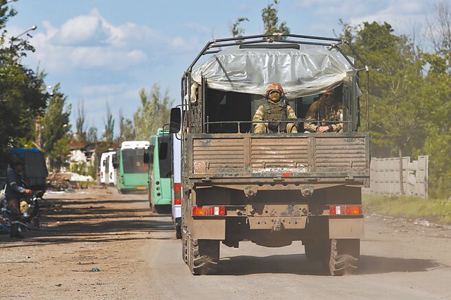 圖為5月20日，載著烏克蘭武裝人員的巴士駛離馬立波。 （新華社）