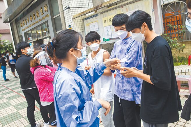 国内确诊案例轻症者眾多，防疫保单对「居家照护」从宽认定。图为中和卫生所20日大排长龙，现场工作人员一一分发号码牌后採一进一出方式，让等待民眾依序进入办理。（杜宜谙摄）