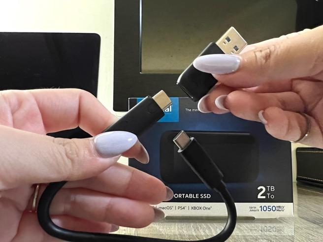 美光科技「Crucial X8 SSD行动硬碟」附有转接头可作USB-C或USB-A连接，方便在不同装置间变换使用。（石欣蒨摄）