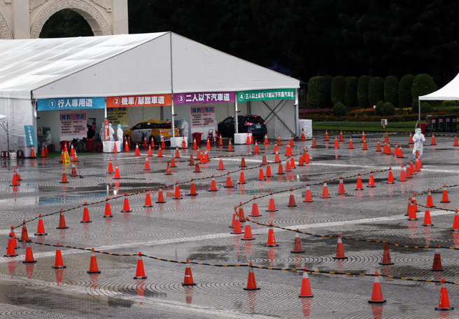 本土疫情持續燒，民眾冒雨至篩檢站採檢領藥。（范揚光攝）