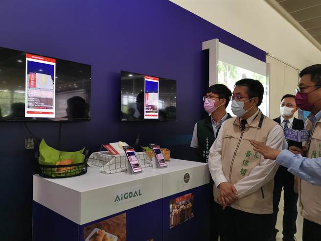 黄伟哲(左)参观亚旭各合作伙伴的应用案例。（刘秀芬摄）