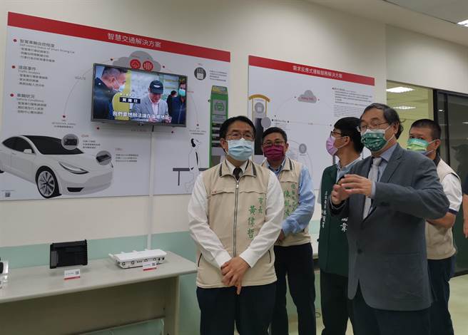 亚旭董事长林成贵(前右)为黄伟哲(前左)解释左镇智慧公车应用。（刘秀芬摄）