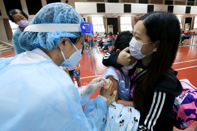 国内疫情严峻，不少家长陪同孩子到学校施打儿童BNT疫苗。非新闻当事人。（图／陈麒全摄）