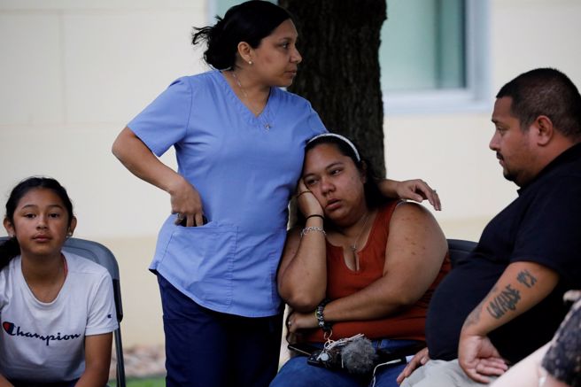 许多家长第一时间找不到自己的孩子，只能在外默默等候，承受未知的折磨。(图/路透社) 
