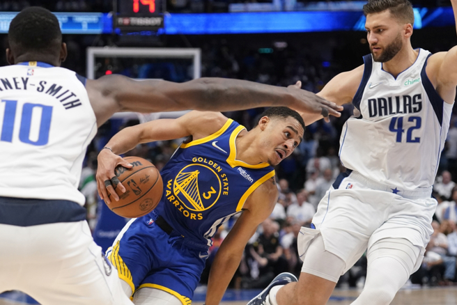 勇士队Jordan Poole持球突破独行侠球员包夹。（美联社）