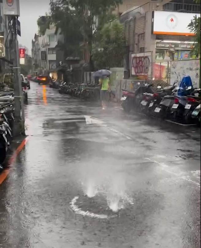 台北市连日大雨，台北市议员大安文山参选人林岳龙发现，信义路人孔盖昨出现地下粪污水喷泉奇景，喷泉高度达1公尺以上，人孔盖也不断掀动、震声骇人。（林岳龙提供）