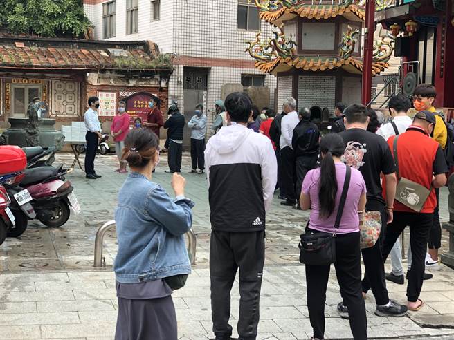 洪志恒今天在浯岛城隍庙口免费发送700份快筛剂，吸引大批乡亲排队领取。（李金生摄）