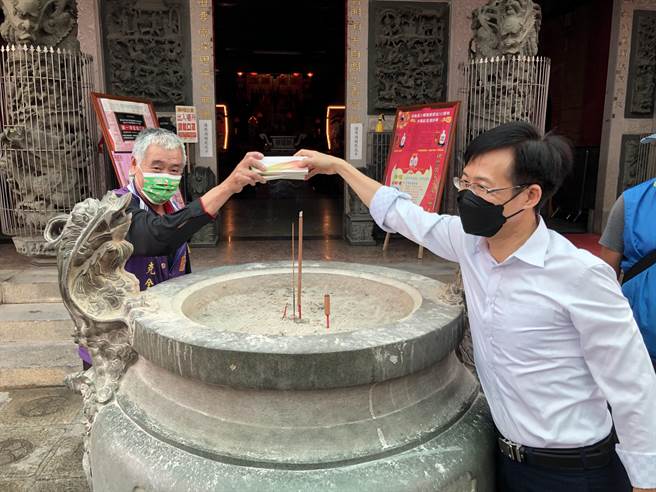 洪志恒与浯岛城隍庙管委会总干事张克全持快筛剂过炉，祈求神明加持让疫情早日散去。（李金生摄）