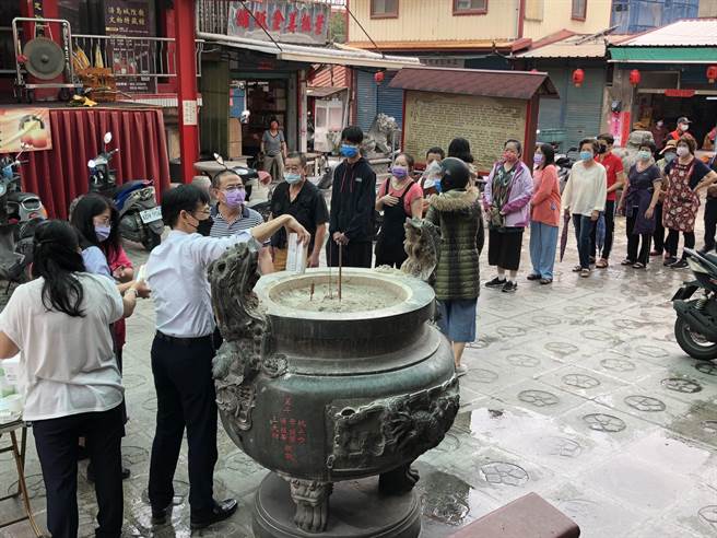 洪志恒持快筛剂过炉后，再发给排队的乡亲，表现贴心的另一面。（李金生摄）