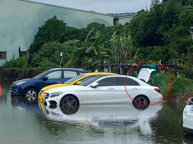 男子拍下新北市泰山区某停车场部分场地淹水，有辆宾士车「脚踢感应」疑似被泡到秀逗。（翻摄自脸书ㄨㄚ是泰山人）