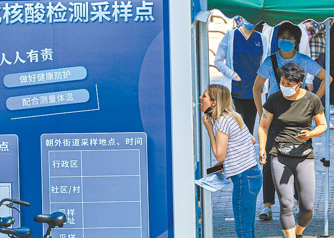 大陆核酸检测费用再现调降，单人单次降至不高于每人份16元。图为北京民眾在朝阳区一处核酸检测点接受採样。（中新社）