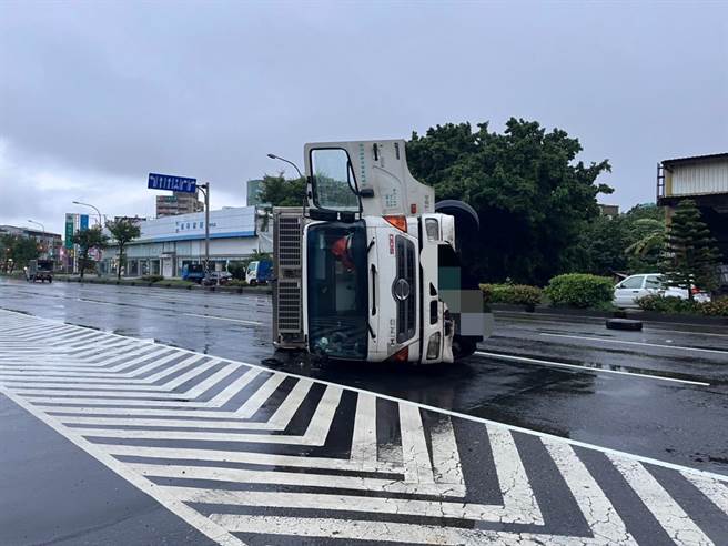 彰化市中华西路积水，大货车打水漂自撞分隔岛翻覆。（彰化分局提供／吴敏菁彰化传真）