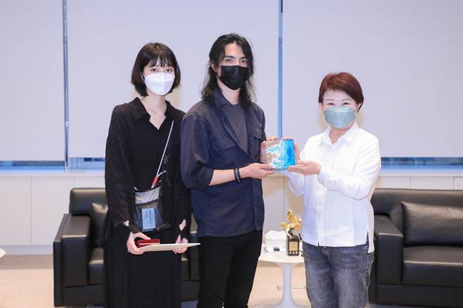 李政瀚(中)将有两人亲笔签名的获奖专辑赠送卢秀燕（右）留念。（台中市新闻局提供／谢琼云台中传真）