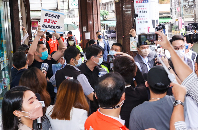 行政院院长苏贞昌和卫福部部长陈时中27日上午前往新北市欣民药局视察后离开时，遭到民眾举牌抗议。（罗永铭摄）