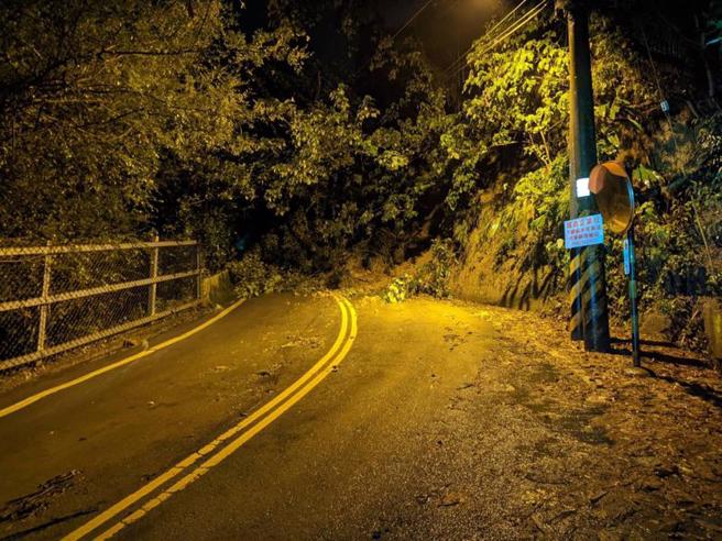 台中市石冈区金星里头坪巷产业道路边坡，26日晚间约11时发生坍塌，影响往来人车通行。台中市警察局东势分局立即派员到场交管。（图/ 中央社）