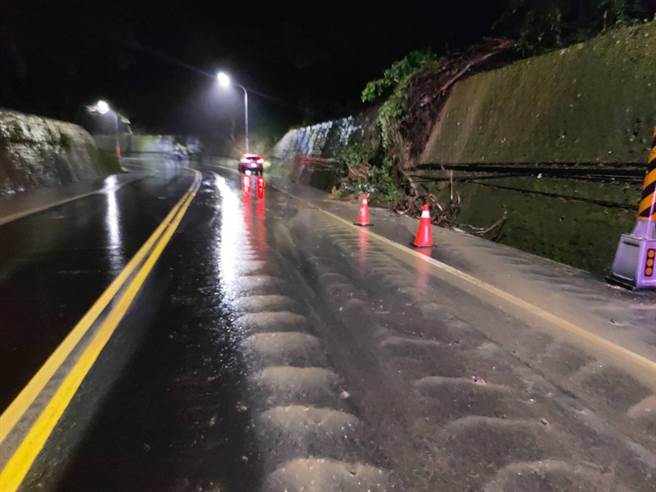 苗栗縣通霄鎮苗128線道發生邊坡坍塌，水流經過路面有如小河般，警方到場警戒並通報搶修。（通霄警分局提供／謝明俊苗栗傳真）